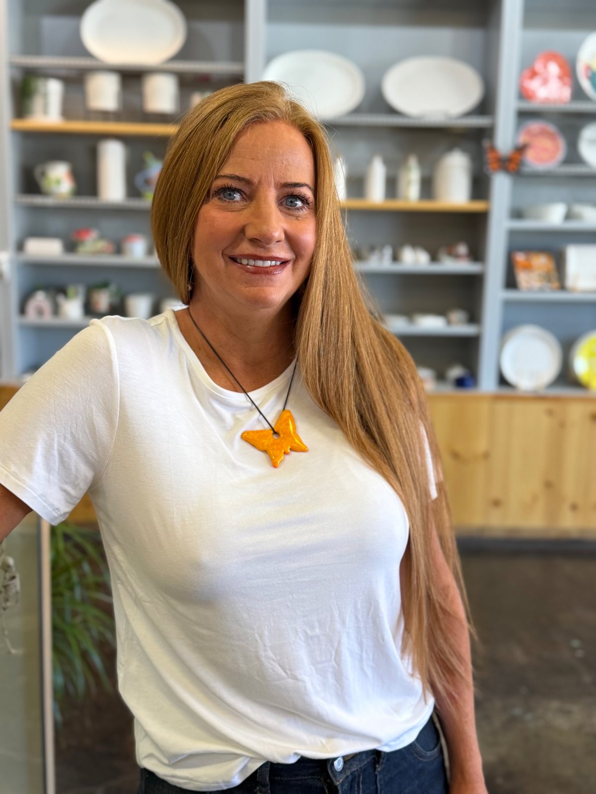 Guest wearing an orange fused glass butterfly pendant