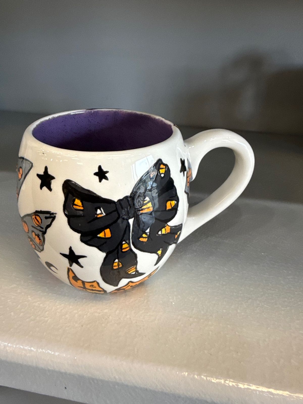 Hand painted Halloween mug with a black bow and candy corn accents at Paint Fusion Park City