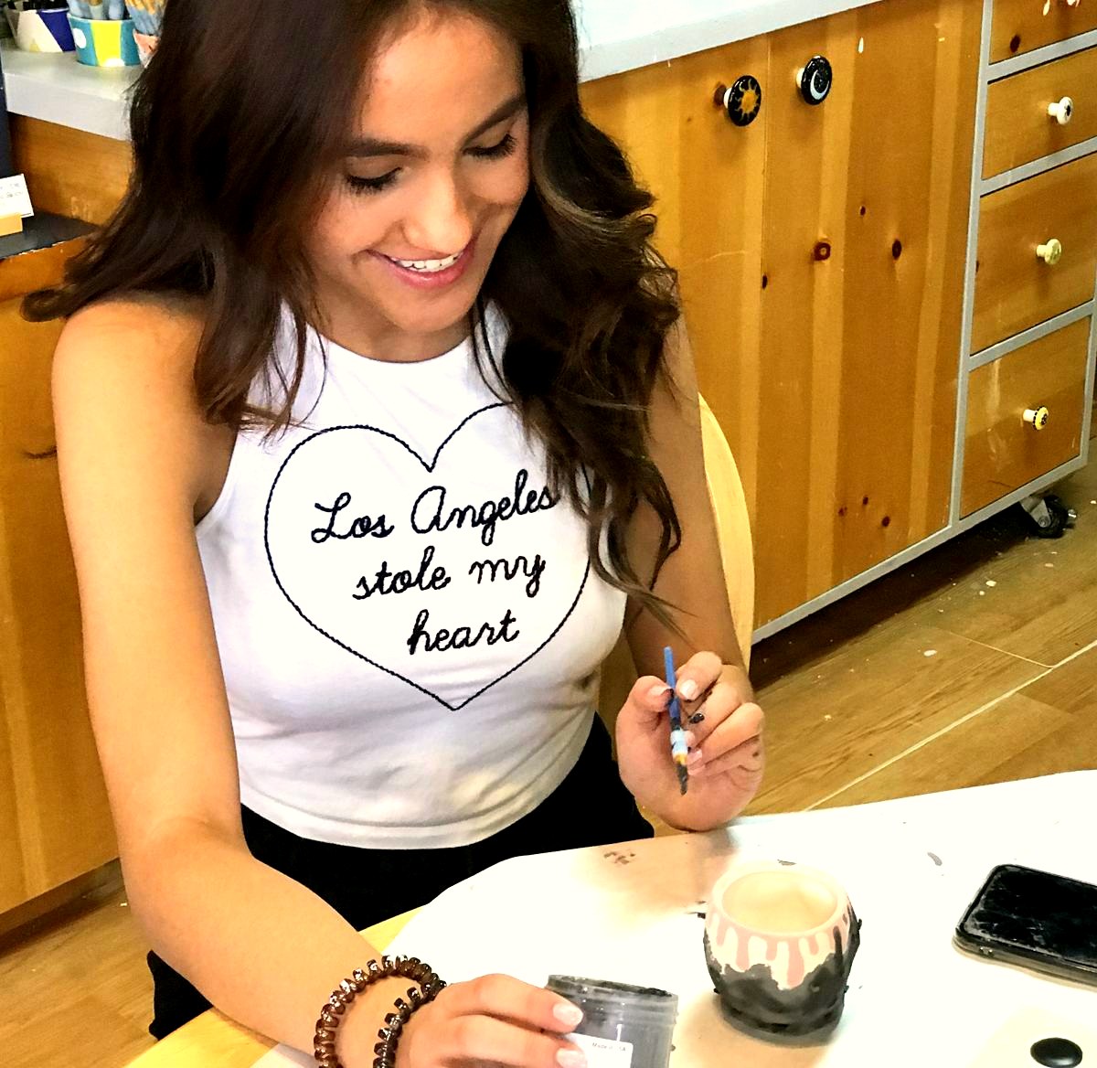 A customer painting a ceramic bowl at Paint Fusion Park City